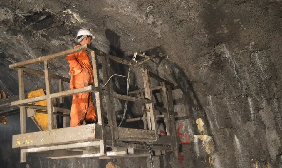 A technician on a work platform injecting resin into the crown of USBRL tunnel T-5