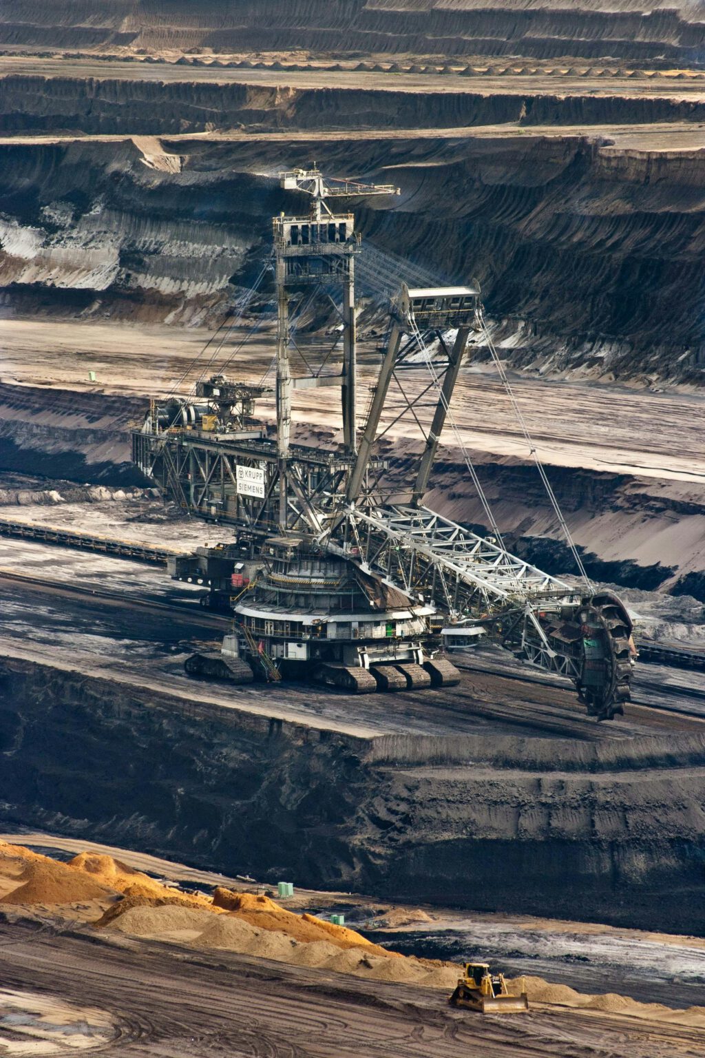 Silver steel mining crane on black rocky soil during daytime